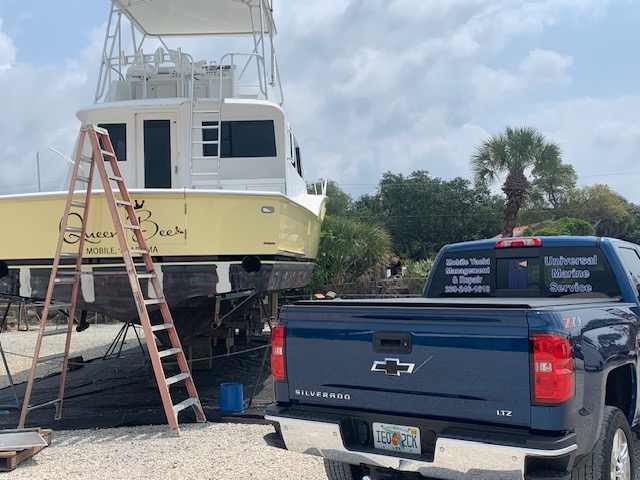 Universal Marine Service truck alongside a sportfishing boat on the hard