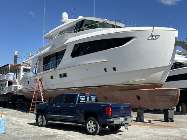 Universal Marine Service truck alongside a yacht on the hard during a haul-out